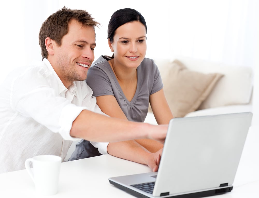 Parents using a laptop together, symbolising integrated communication in childcare management