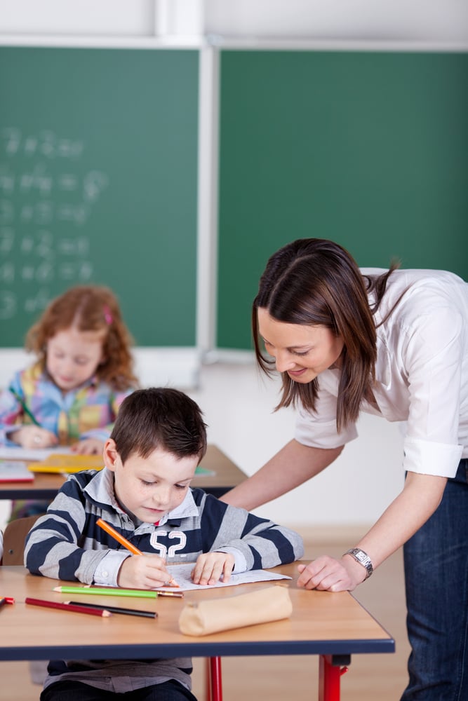Teacher helping student one on one at the classroom