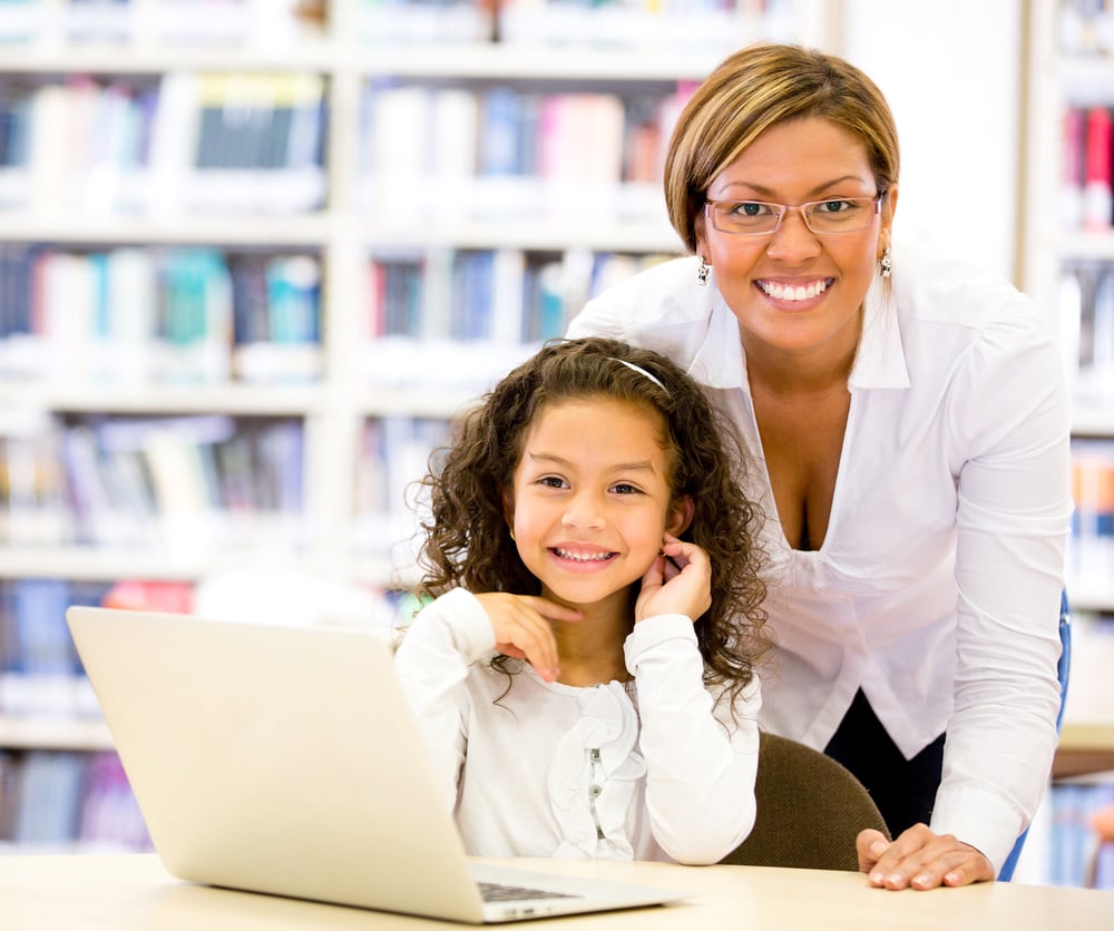 Girl with a computers teacher looking very happy