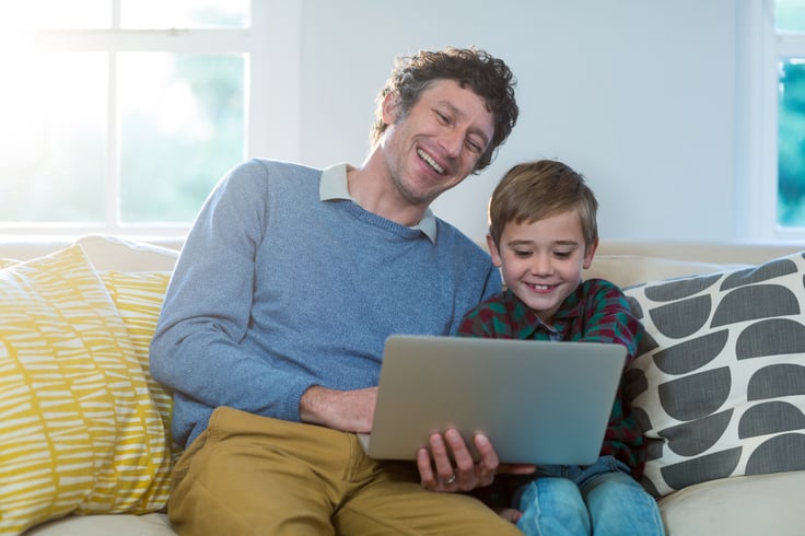 Father and son using laptop at home
