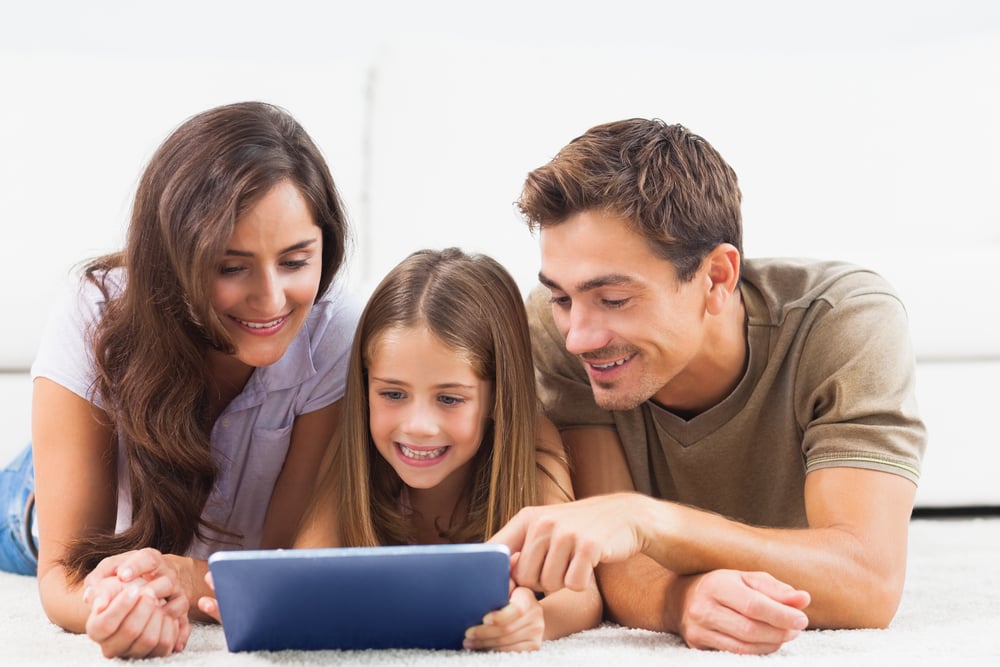 Parents and child viewing information on a tablet