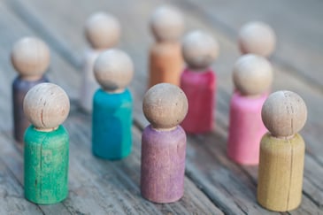 small, people-shaped wooden objects with various colors