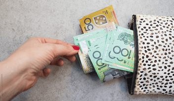woman pulling australian currency from wallet