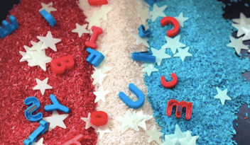 red, white, and blue rice with magnet letters and plastic stars