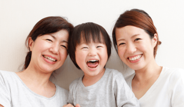 two moms smiling with their young son - used a website contact form