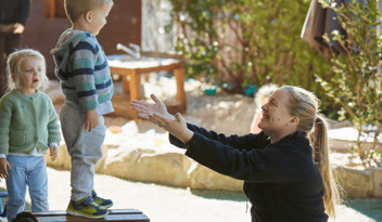 blonde woman reaching out her arms to hold little blonde boy