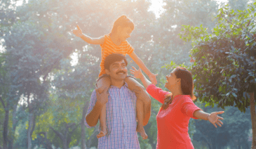 young daughter on father's shoulders while mom smiles and reaches towards her