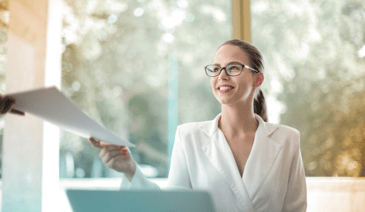 woman holding paper at desk