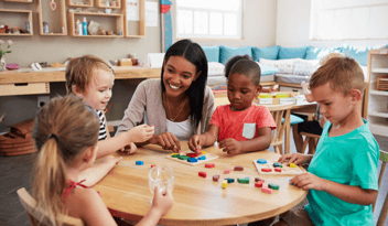 teacher sitting at table with young children, week of the young child