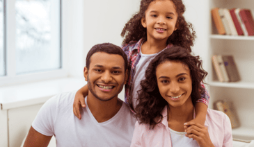 mother, father, and daughter smiling at a childcare center