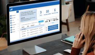 blonde woman talking on cell phone while looking at childcarecrm dashboard on her computer