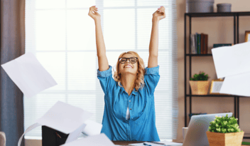 blonde woman with glasses throwing papers up in the air