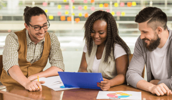 three coworkers looking at charts and reports