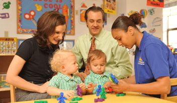 couple with twin boys sitting next to childcare worker