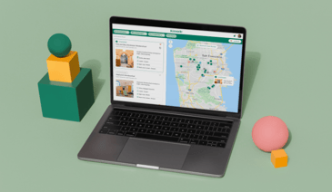 Kinside website on open laptop with green background and shapes