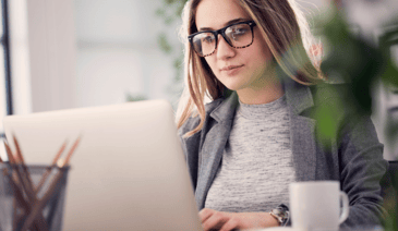 woman with glasses working on computer