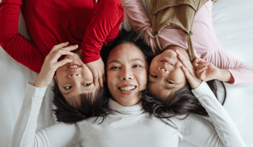 mother and two daughters smiling