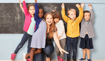 teacher with students near chalkboard