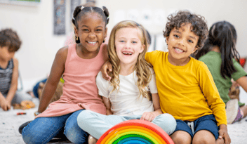 kids in the classroom, next to a rainbow