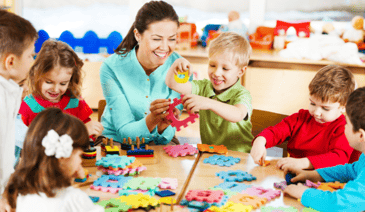 teacher with children building a puzzle: leadership tips