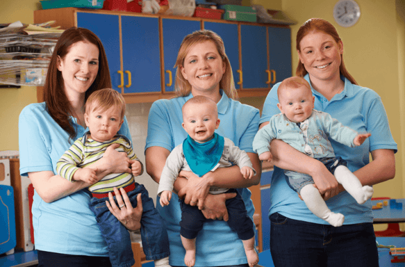 Early childhood teachers holding infants in a nursery setting