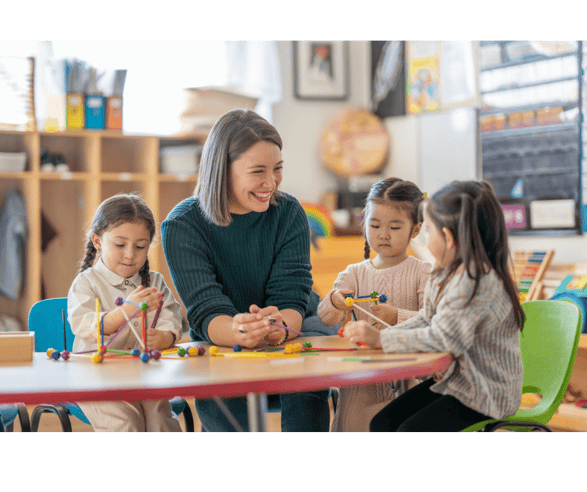 Childcare educator engaging in playtime with three young children