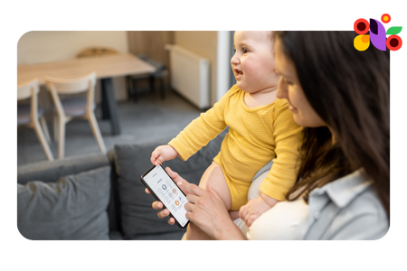 Mom holding baby while sending a text