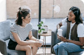 A manager having a touch conversation with a staff member at a childcare center.