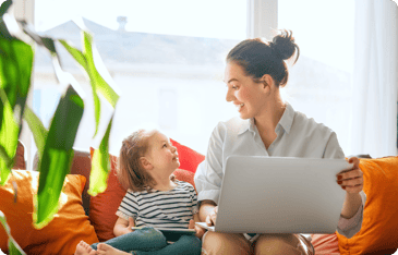 Parent filling out a childcare enrollment form on a laptop while sitting with their child at home.