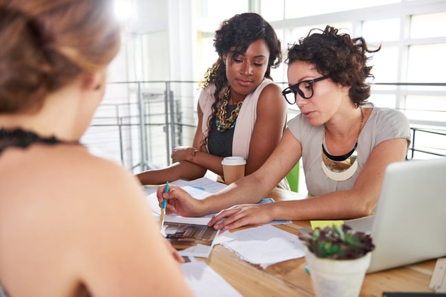 Childcare staff discussing plans at a workspace
